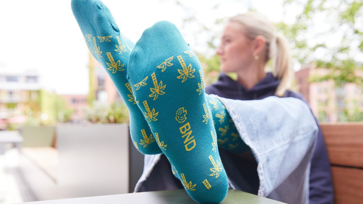 Palmensocken Auf einem Werbefoto streckt eine Person die Socken mit Palmen des BND in die Kamera
