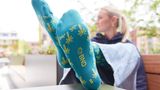 Auf einem Werbefoto streckt eine Person die Socken mit Palmen des BND in die Kamera