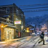 Zugeschneite Straße mit Autos am Abend