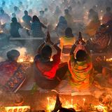 Zwischen Rauch und Feuer betende Menschen