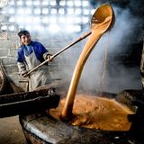 Bauer mit riesen Löffel vor dampfender riesen Schüssel