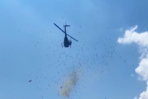 Das Foto zeigt einen Helikopter in Detroit, aus dem Geldscheine regnen