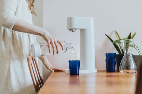Eine Frau benutzt einen Wassersprudler. Stiftung Warentest hat nun sieben Modelle getestet