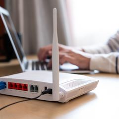 Wlan Reichweite: WLAN-Router steht auf einem Schreibtisch