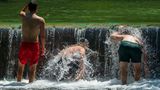 Jugendliche kühlen sich im Eisbach im Englischen Garten ab.