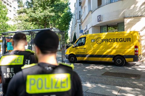 Polizisten stehen in Berlin am Kurfürstendamm vor dem Geldtransporter, den die Täter ausrauben wollten