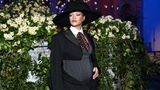 Rihanna im engen schwarzen Kleid, darunter ihr gewölbter Bauch. Sie trägt einen schwarzen Hut dazu
