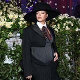 Rihanna im engen schwarzen Kleid, darunter ihr gewölbter Bauch. Sie trägt einen schwarzen Hut dazu