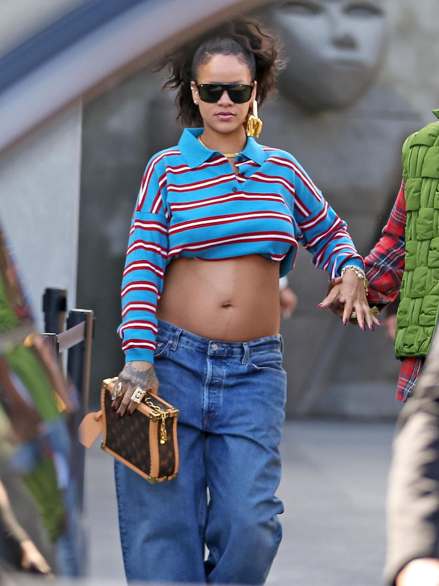 Rihanna in einem langärmeligen Poloshirt, das sie zu einem bauchfreien Modell umfunktioniert hat