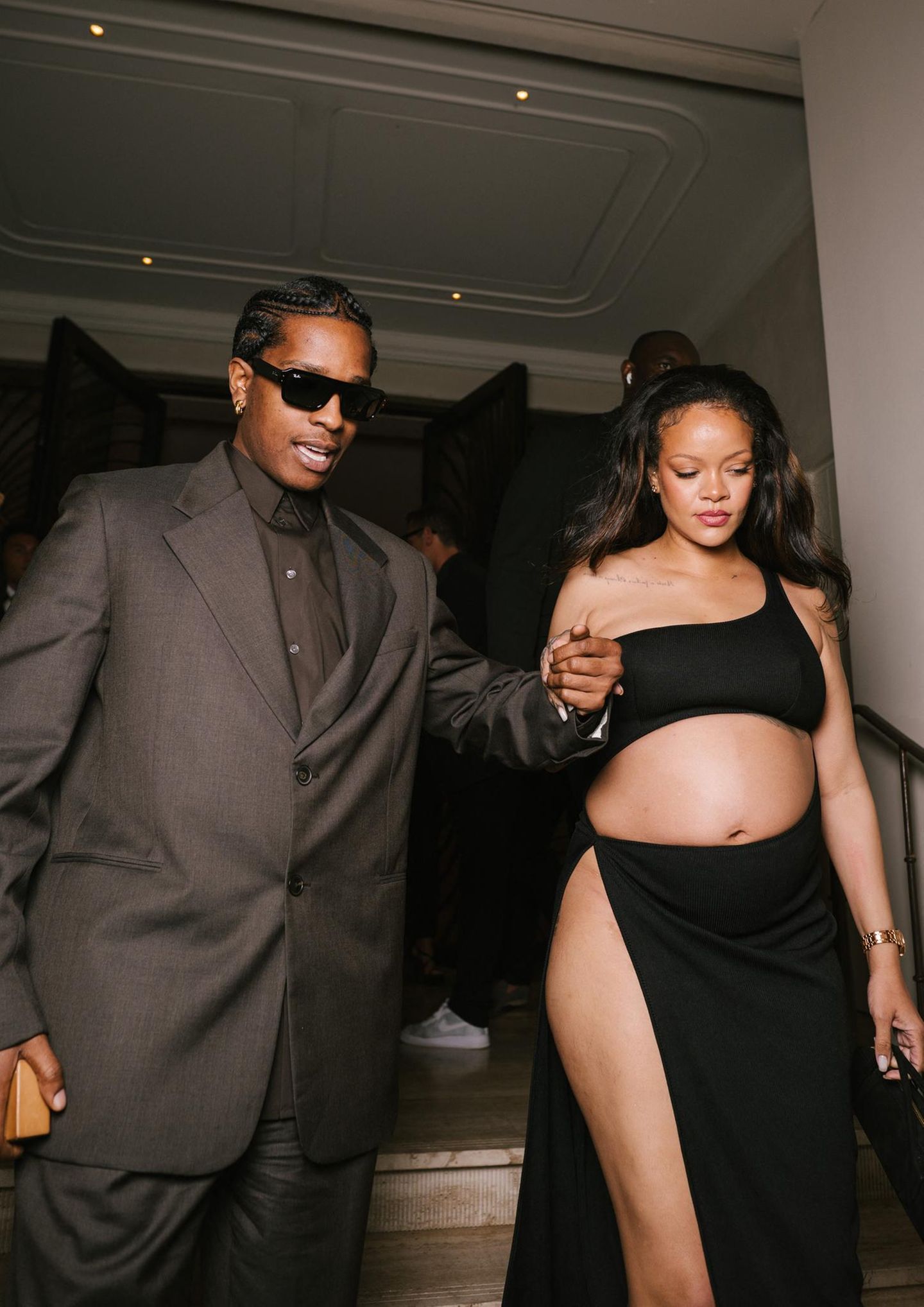 Rihanna im schwarzen Kleid, aber bauchfrei. Neben ihr Asap Rocky im dunklen Anzug