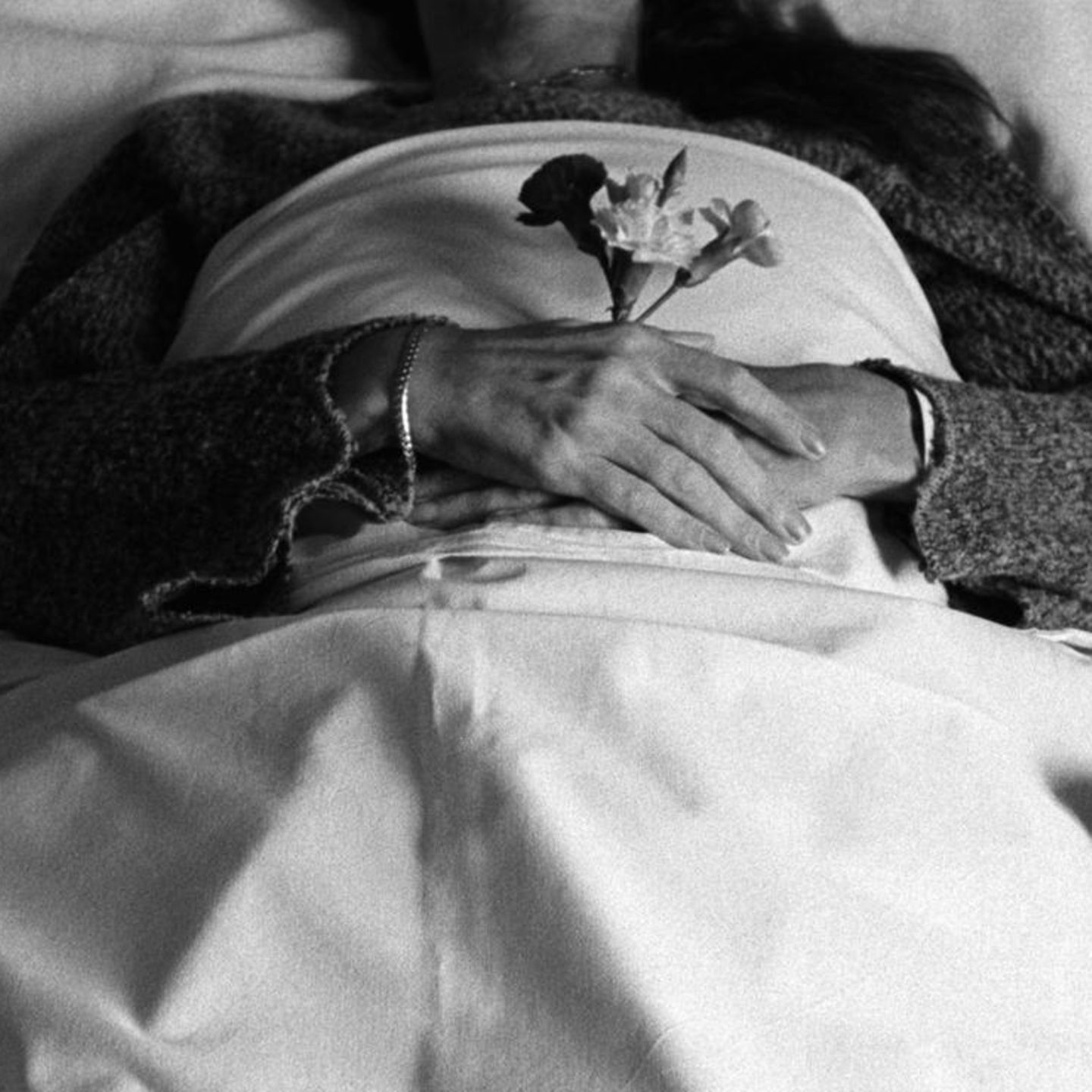 Körper in weiß gehüllt mit einer Rose in der Hand