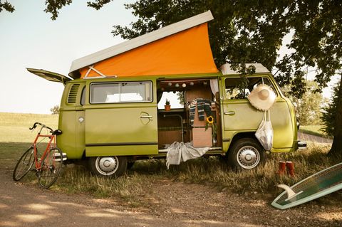 Wildcampen: Ein grüner Van hat das Dach ausgeklappt und campt in der Natur