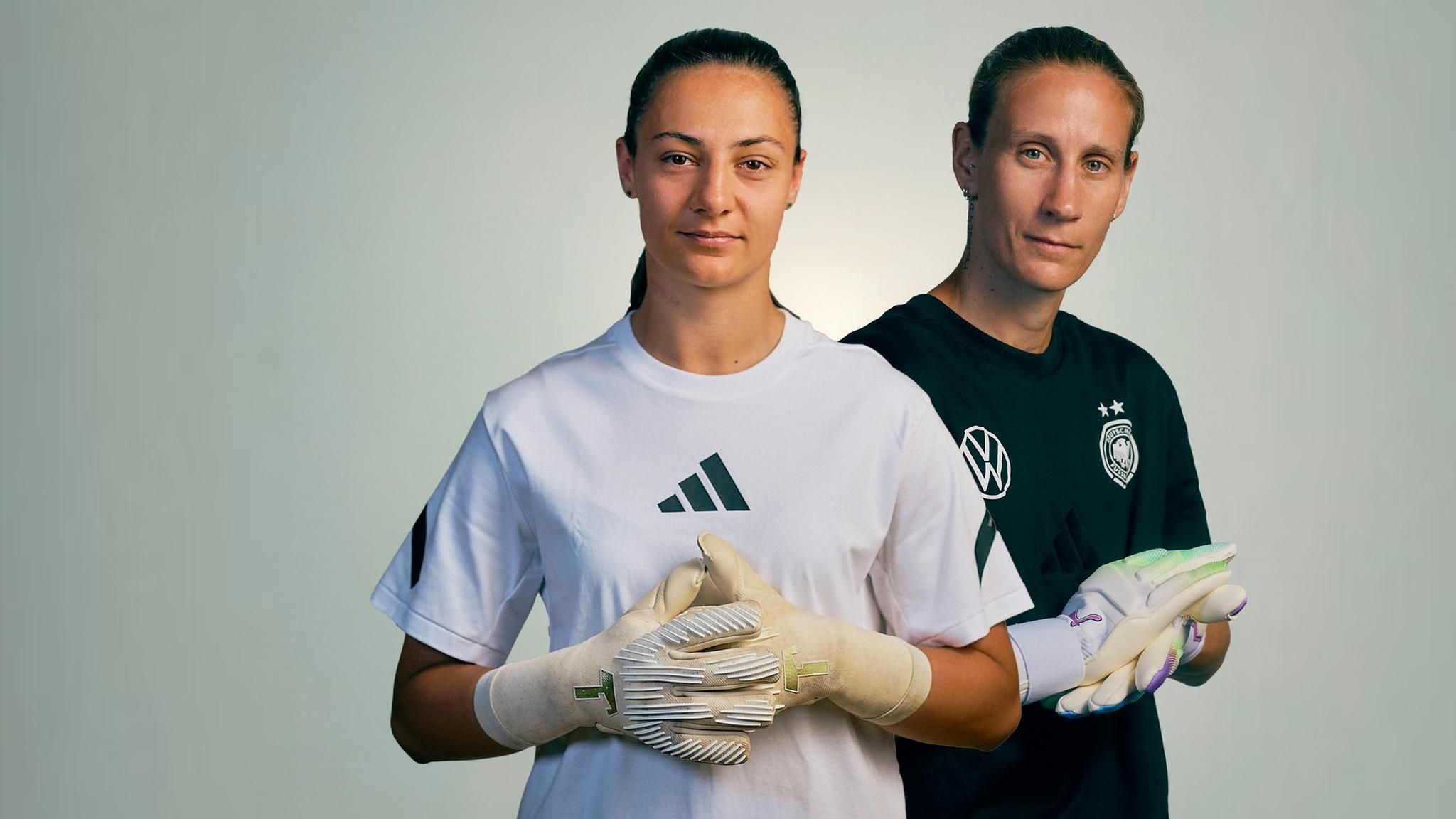 Die Torhüterinnen Ann-Katrin Berger und Maria Luisa Grohs posieren in Handschuhen für ein Foto