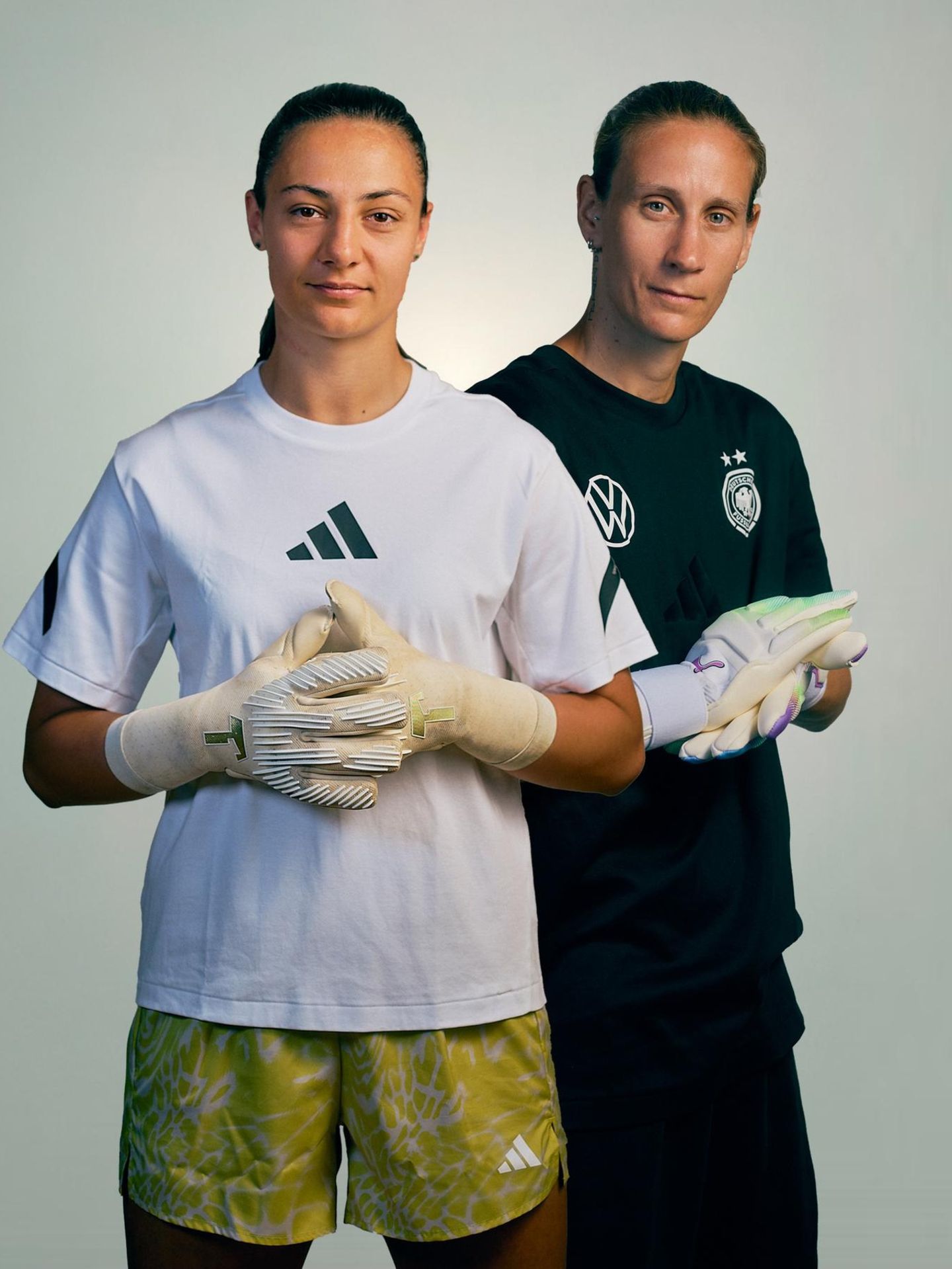 Die Torhüterinnen Ann-Katrin Berger und Maria Luisa Grohs posieren in Handschuhen für ein Foto