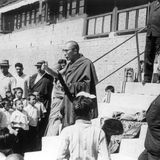 Der Dalai Lama steht vor Kindern und Erwachsenen und spricht