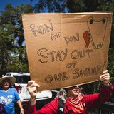 Diese Demonstrantin fordert Floridas Gouverneur Ron de Santis und US-Präsident Donald Trump auf, sich aus den Sümpfen fernzuhalten.