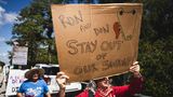 Diese Demonstrantin fordert Floridas Gouverneur Ron de Santis und US-Präsident Donald Trump auf, sich aus den Sümpfen fernzuhalten.