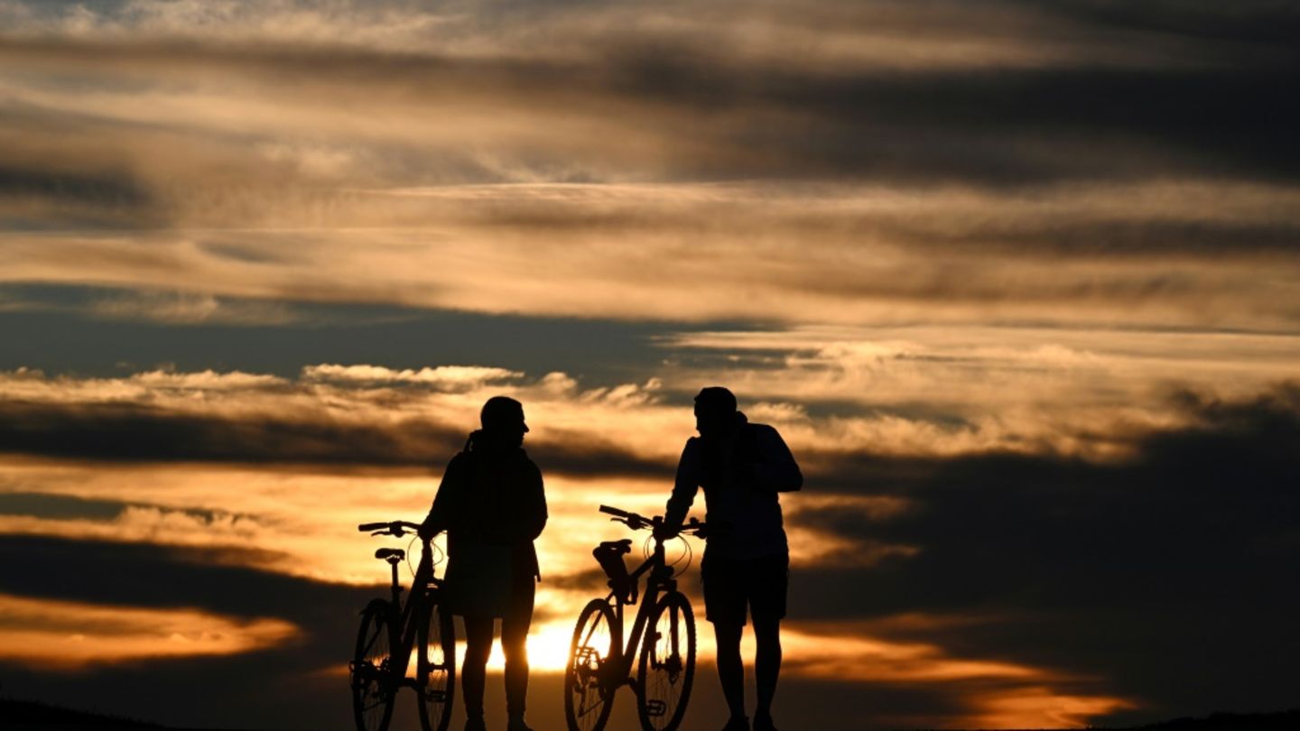 Menschen mit Fahrrädern bei Sonnenuntergang