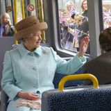 Die Queen sitzt in einem Zug und winkt nach draußen