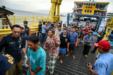 Überlebende gehen am Hafen von Ketapang an Land
