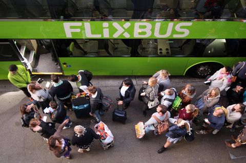 Wartende Passagiere stehen vor einem Flixbus