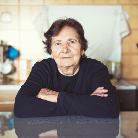 Schützen Impfungen vor Alzheimer? Portrait einer älteren Frau sitzend am Tisch