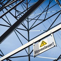 Ein Schild mit der Aufschrift Stromsteuer ist an einem Strommasten angebracht
