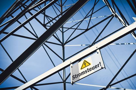 Ein Schild mit der Aufschrift Stromsteuer ist an einem Strommasten angebracht