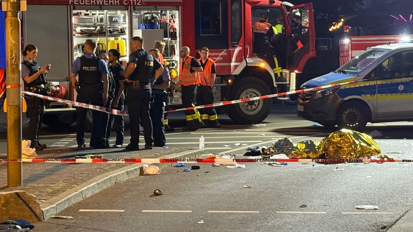 Einsatzkräfte der Polizei und Feuerwehr stehen am Unfallort in Frankfurt