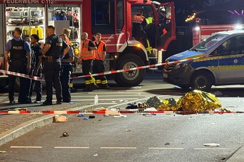 Einsatzkräfte der Polizei und Feuerwehr stehen am Unfallort in Frankfurt