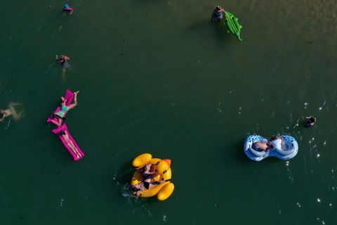 Badende mit Gummitieren auf einem See