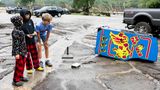 Die Jungs in dem Örtchen Ingram betrachten einen von der Flut mitgerissenen Pac-Man-Automaten. Neben den Todesopfern, die zu beklagen sind, werden mehr als 850 Menschen unverletzt gerettet. Die Menschen hätten sich zum Teil auf Bäume gerettet, um nicht von den Fluten mitgerissen zu werden