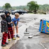 Die Jungs in dem Örtchen Ingram betrachten einen von der Flut mitgerissenen Pac-Man-Automaten. Neben den Todesopfern, die zu beklagen sind, werden mehr als 850 Menschen unverletzt gerettet. Die Menschen hätten sich zum Teil auf Bäume gerettet, um nicht von den Fluten mitgerissen zu werden