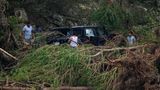 Dieses Auto wurde in der Nähe des Mystic-Ferienlagers angeschwemmt. Die Männer schauen, ob noch was zu retten ist