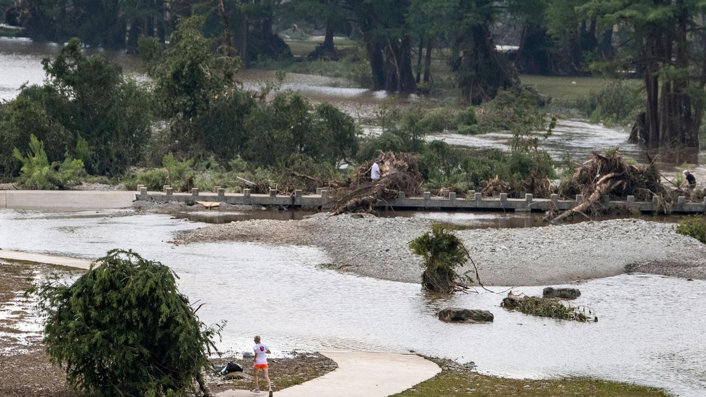 Ein Jogger macht einen Umweg um einen überfluteten Laufweg am Ufer in Kerrville. Der Guadalupe Fluss sei ein Zusammenfluss zweier Quellarme, erklärt der Stadtverwalter auf einer Pressekonferenz. Auf beide habe es stark geregnet. Vor Kerrville seien die Wassermassen dann im Guadalupe Fluss zusammengeflossen, was zu dem schnellen Anstieg des Pegelstandes geführt habe