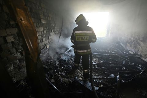 Einsatzkraft der Feuerwehr in zerstörtem Haus in Charkiw