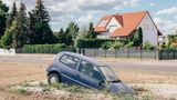 Bewohner eines Ortes in der Lausitz haben ein verunfalltes Auto als Mahnmal für mögliche Erdrutsche aufgestellt