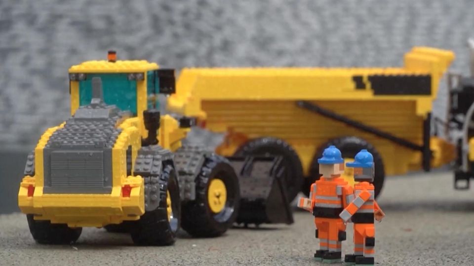 Legoland zeigt Mega-Baustelle des Fehmarnbelt-Tunnels Gelber Traktor aus Lego steht hinter zwei Lego-Figuren