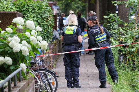 Die Polizei sichert die Straße an einem Mehrfamilienhaus in Hamburg-Barmbek