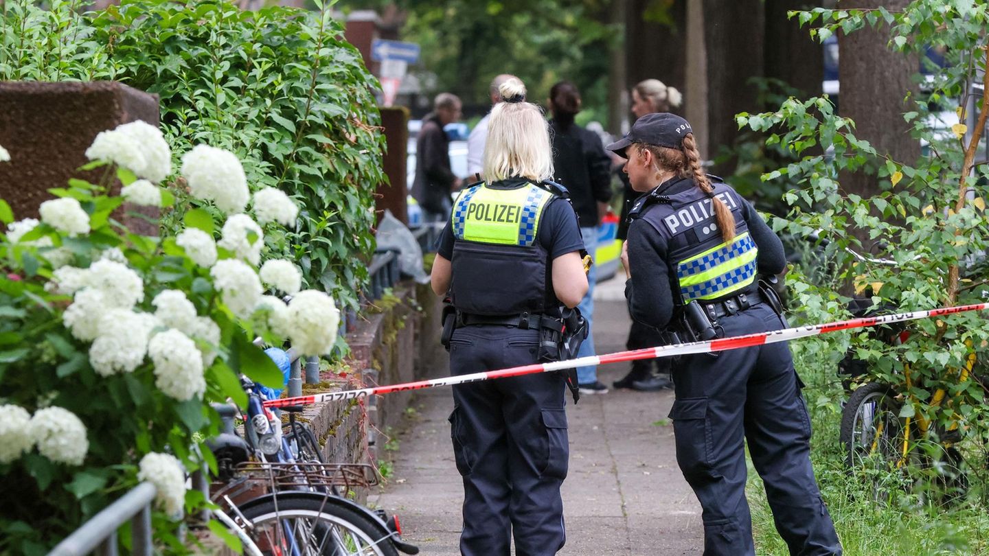 Die Polizei sichert die Straße an einem Mehrfamilienhaus in Hamburg-Barmbek