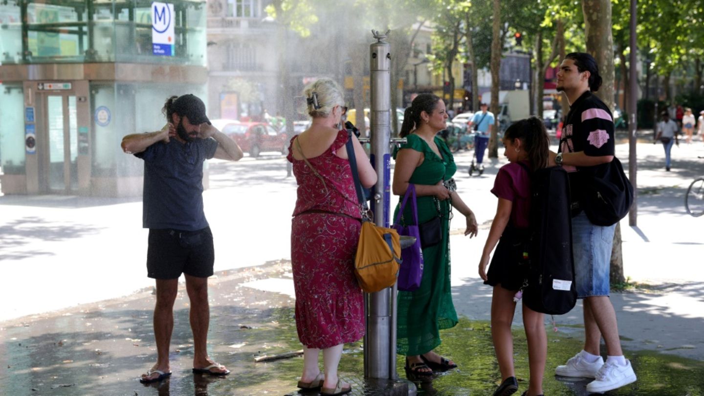 Menschen kühlen sich in Springbrunnen ab