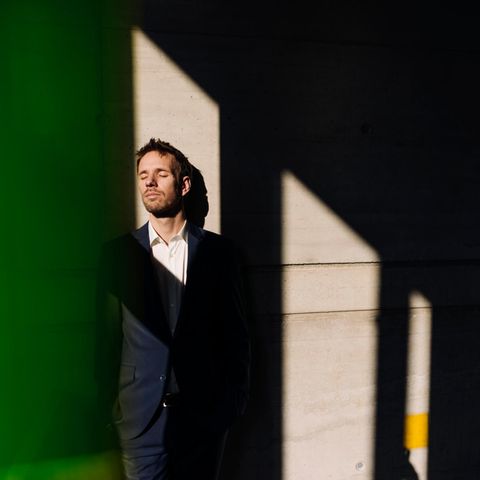 A man leans against a wall