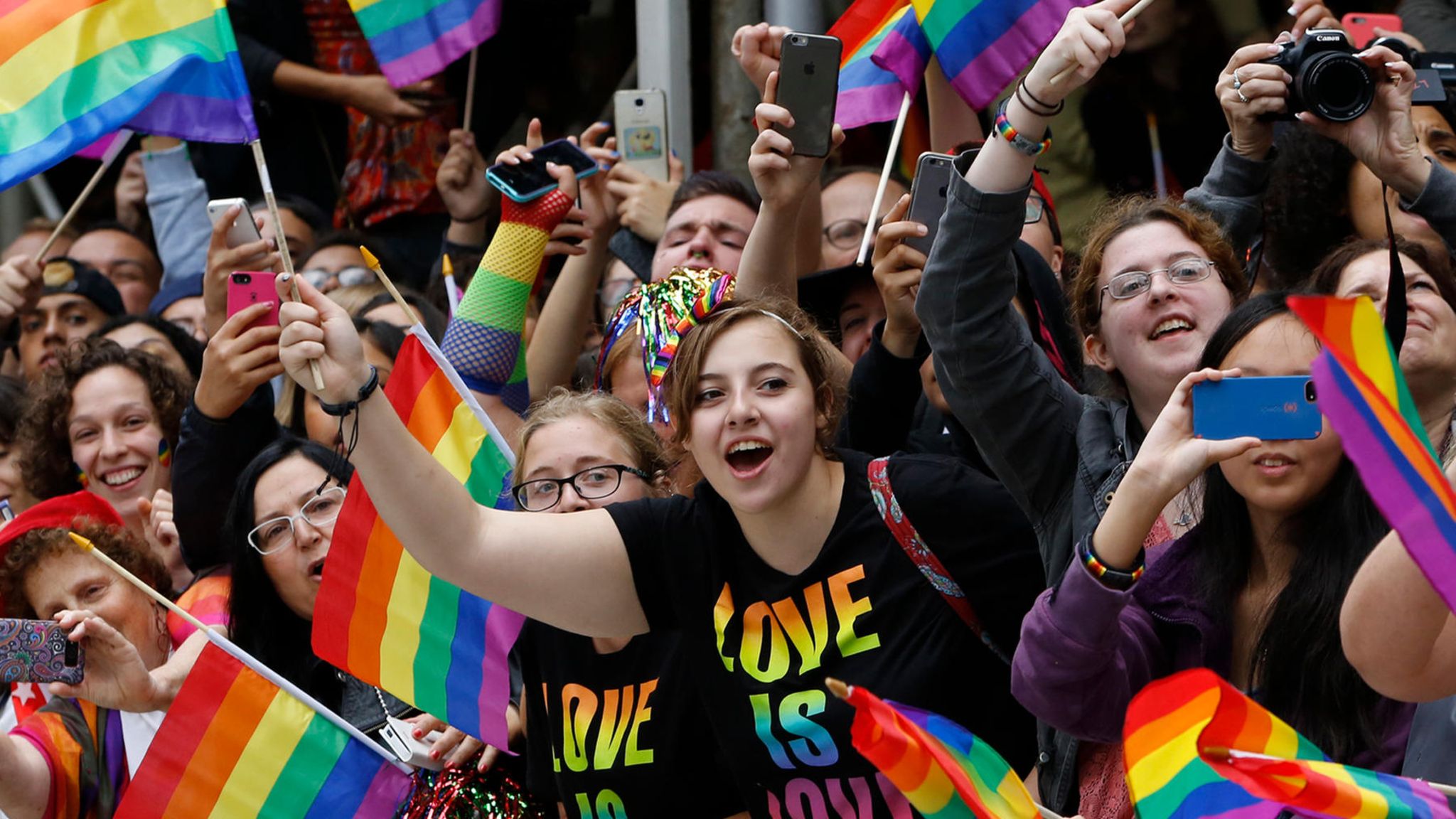 Menschen mit Regenbogenflaggen bei einer Pride Parade