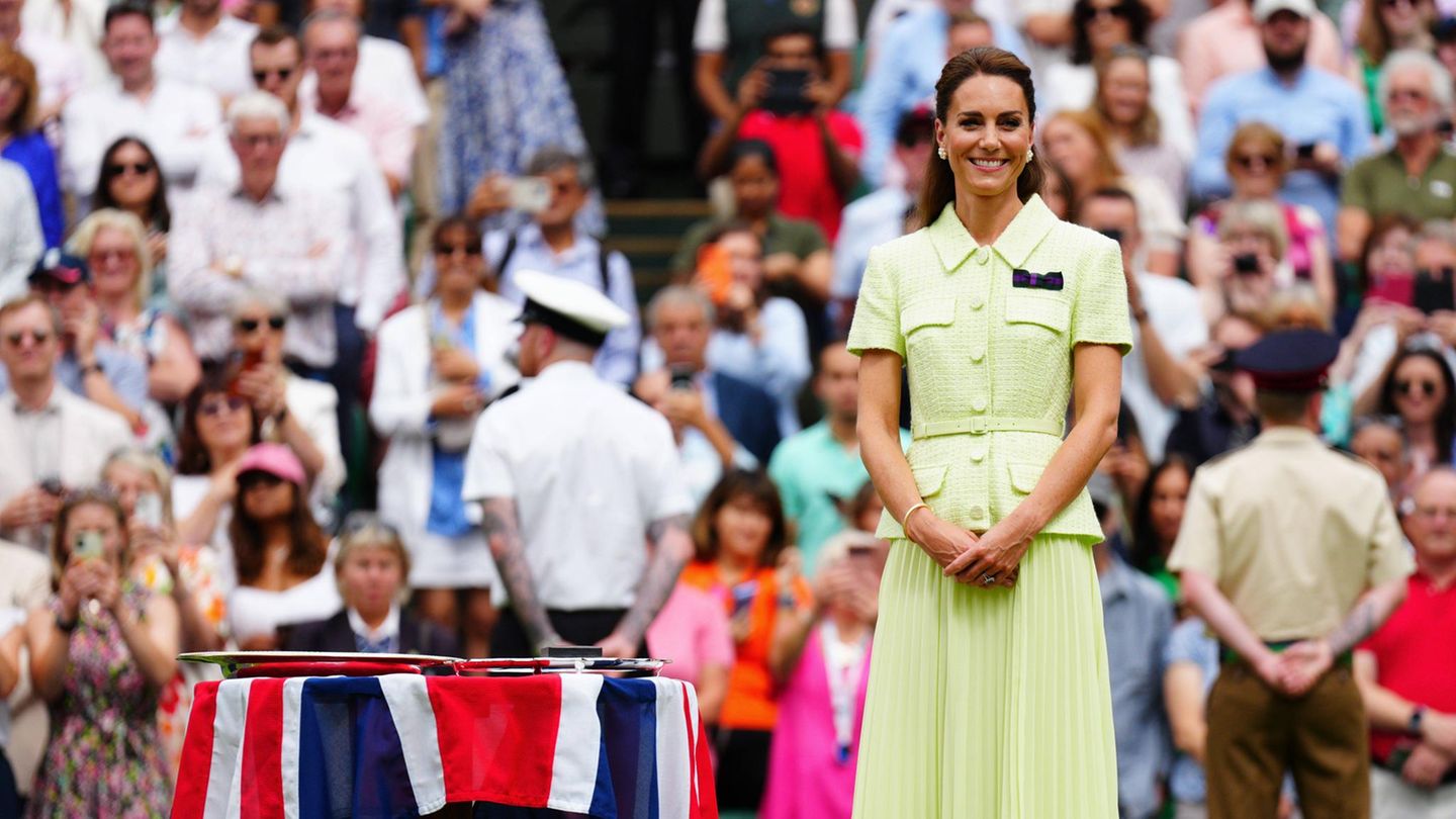 Kate im sommergelben Dress neben der Siegerschale der Damen 2023