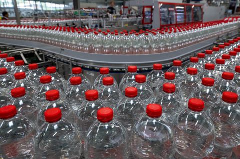 Flaschen mit Mineralwasser laufen über eine Produktionslinie der Roxane GmbH in Jessen, Sachsen-Anhalt