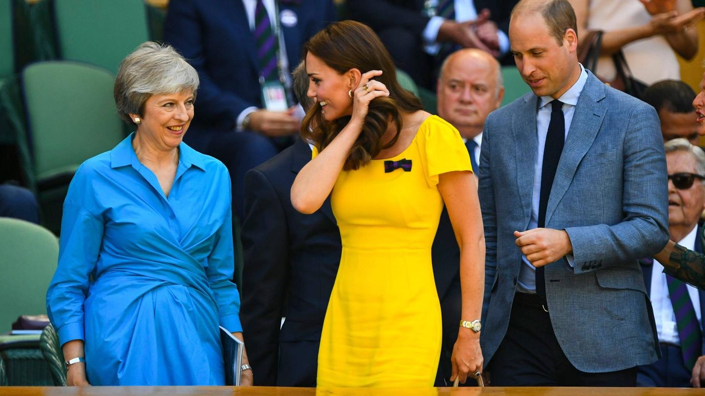 Kate im knallgelben Kleid von Dolce und Gabbana, sie streicht sich durch das braune Haar