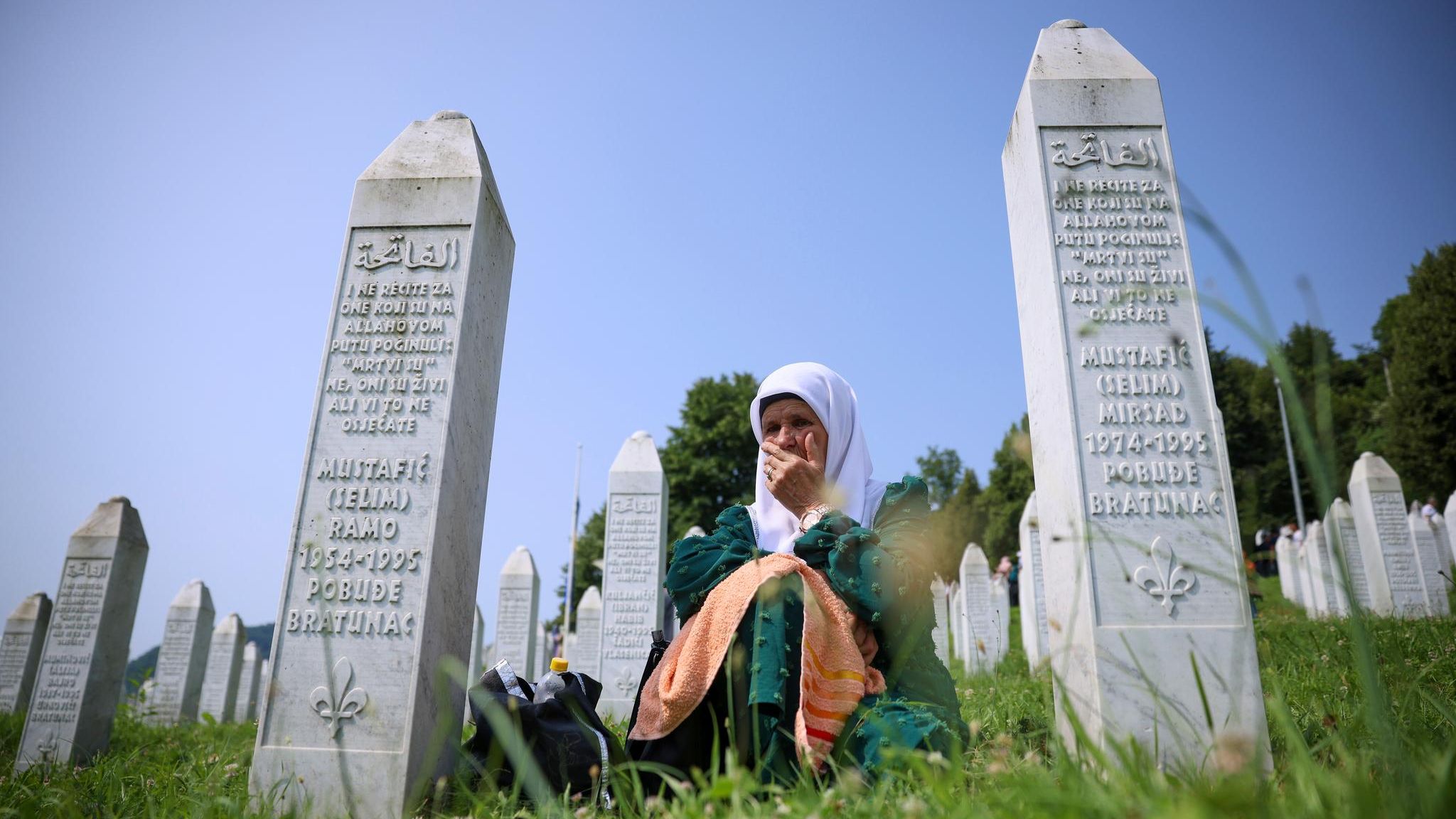 Eine muslimische Frau trauert zwischen Grabsteinen um die Opfer des Massakers von Srebenica