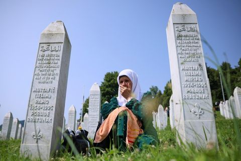 Eine muslimische Frau trauert zwischen Grabsteinen um die Opfer des Massakers von Srebenica