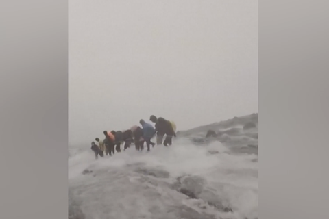 Bergsteiger stehen plötzlich in reißendem Fluss am Hang