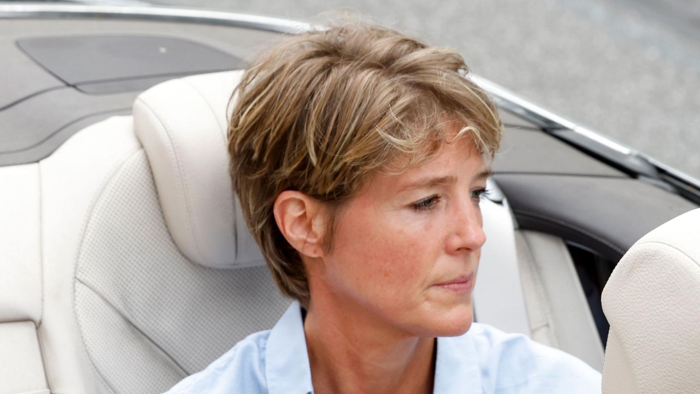 Christina Block sitzt auf der Rückbank eines Cabrios